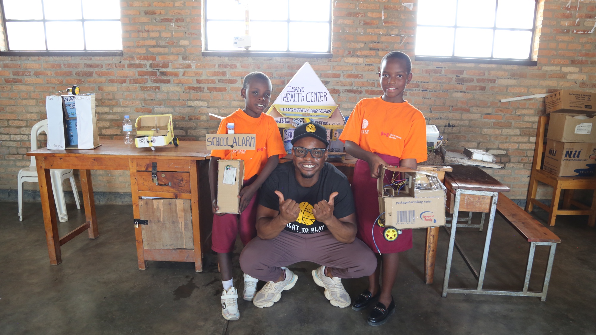 Duan Asemota with Right To Play students at the Plug in Play science fair in Rwanda, November 2025