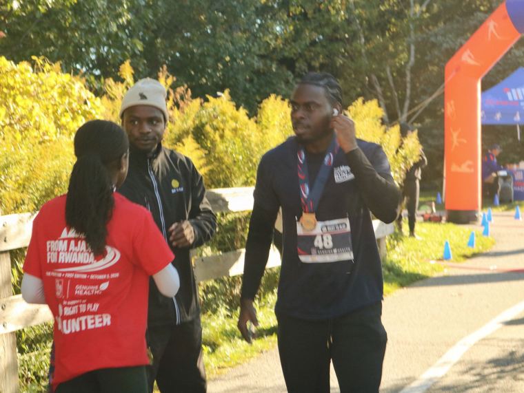 Volunteer with finishers near the arch