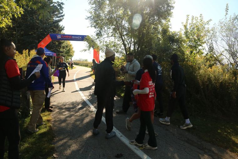 Runners and volunteers near the start and finish arch