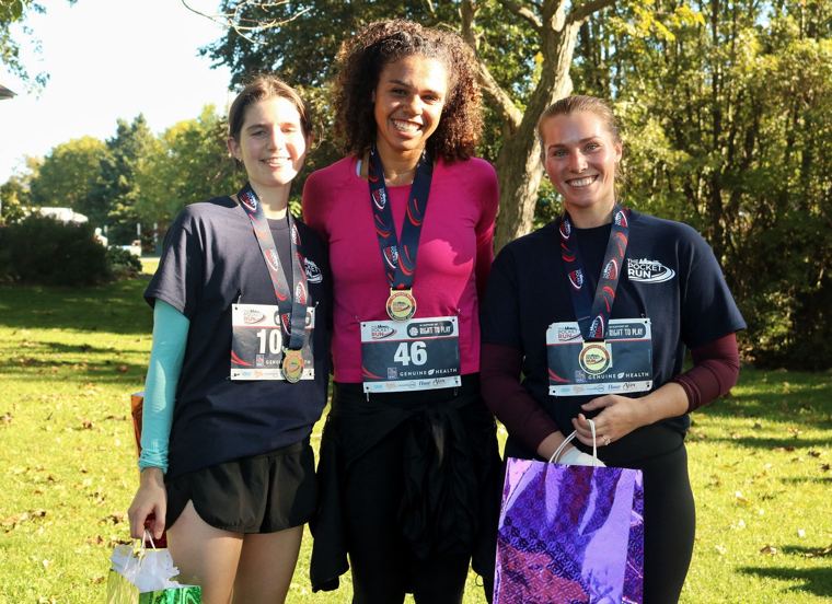 Three finishers posing with medals