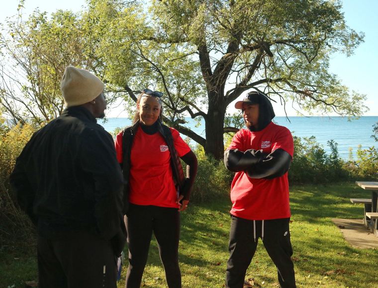 Volunteers in red by the lake