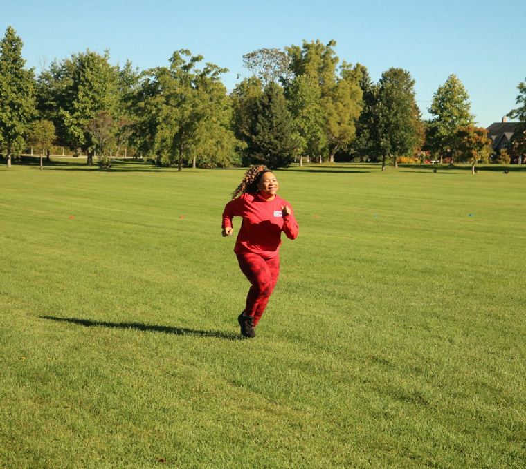 Sprinter in red crossing the field