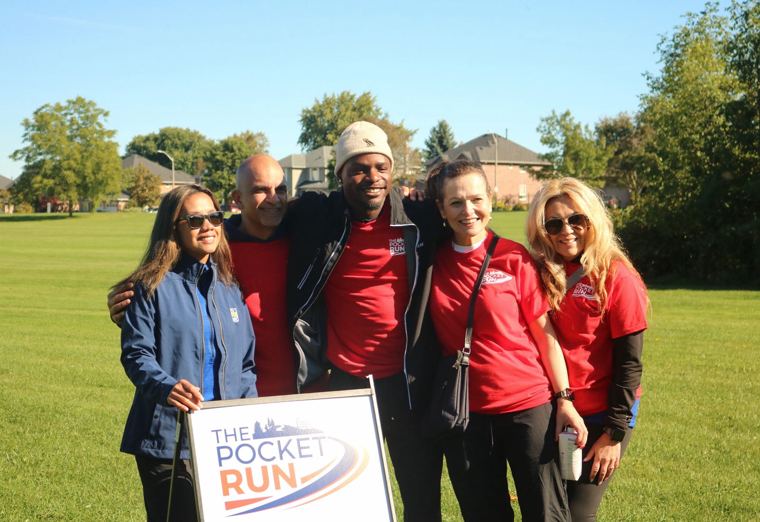 Volunteers posing with The Pocket Run sign