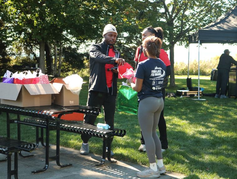 Volunteer handing out gift bags at a table