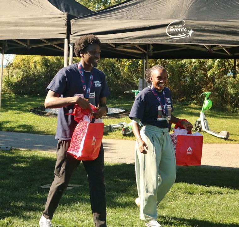 Two participants carrying gift bags