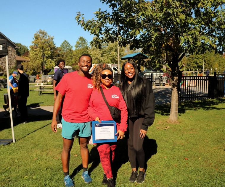 Three friends holding the Mayor's certificate